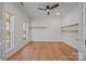 Bright, empty bedroom with hardwood floors, a ceiling fan, and natural light from a large window at 1221 Cochrane Woods Ln, Matthews, NC 28105