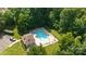 This aerial shot shows a clean community pool surrounded by ample greenery and lounge chairs at 1221 Cochrane Woods Ln, Matthews, NC 28105