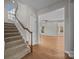 View of the stairs and hardwood floors leading to an open living space with plenty of natural light at 1221 Cochrane Woods Ln, Matthews, NC 28105