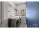 A laundry room with wood countertop, front load washer and dryer, blue walls, and a window at 1221 Cochrane Woods Ln, Matthews, NC 28105