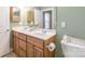 Bathroom with double sink vanity, decorative mirror, and light green paint at 1243 Glory Ct, Oakboro, NC 28129