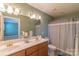 Bathroom with double vanity, striped shower curtain, and neutral color palette at 1243 Glory Ct, Oakboro, NC 28129