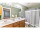 Bathroom with double sink vanity, striped shower curtain and light green paint at 1243 Glory Ct, Oakboro, NC 28129