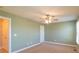 Minimalist bedroom with a ceiling fan and carpeted floor, adjacent to the bathroom at 1243 Glory Ct, Oakboro, NC 28129