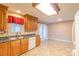 Kitchen featuring wood cabinets, white appliances, and access to the backyard through French doors at 1243 Glory Ct, Oakboro, NC 28129