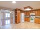 Open kitchen with wood cabinets, tile floors, and white appliances at 1243 Glory Ct, Oakboro, NC 28129