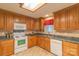 Well-lit kitchen with wooden cabinets, white appliances, and a modern countertop at 1243 Glory Ct, Oakboro, NC 28129