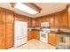 Spacious kitchen with ample wood cabinets, granite countertops, and white appliances at 1243 Glory Ct, Oakboro, NC 28129