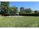 Aerial view of a kidney-shaped pool, lawn, and trees at 1300 Reece Rd # G-18, Charlotte, NC 28209