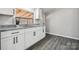 Well-lit kitchen featuring granite counters, gray wood floors, and new appliances at 137 S Penny St, Lancaster, SC 29720