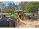 Stone patio with grill, seating area, and lush landscaping at 145 Ashton Woods Ct, Mount Holly, NC 28120