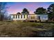 Rear view of a single story house with a wooden deck and manicured lawn at dusk at 145 Morcroft Ln, Cleveland, NC 27013