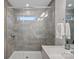 Modern bathroom boasts a glass enclosed tiled shower, sleek fixtures, and ample natural light at 16022 Red Buckeye Ln, Huntersville, NC 28078