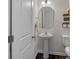 Cozy powder room features a pedestal sink, a decorative mirror, and a toilet with wood-look floors at 16022 Red Buckeye Ln, Huntersville, NC 28078