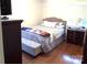 Bedroom with queen bed, light wood floors, and a light grey bench at the foot of the bed at 1723 Oak St, Charlotte, NC 28269