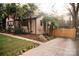 Home exterior with palm trees, a concrete driveway, and mature landscaping, offering a tranquil and inviting outdoor space at 1723 Oak St, Charlotte, NC 28269