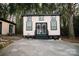 Exterior view of home with a concrete driveway, two buildings, mature trees, and seasonal decor, providing a welcoming ambiance at 1723 Oak St, Charlotte, NC 28269