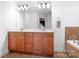 Bathroom with double sink vanity, large mirror, and separate bathtub with tile surround at 1790 Kathy St, Newton, NC 28658