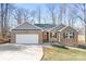 Charming brick and siding home featuring a red front door and attached two-car garage at 1790 Kathy St, Newton, NC 28658