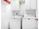 Well-lit laundry room with white washer and dryer, and white cabinets above at 1790 Kathy St, Newton, NC 28658