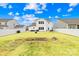 Wide open backyard with a fire pit, green grass, and a white fence and house in the background at 191 Sutters Mill Dr, Troutman, NC 28166