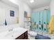 Bright bathroom featuring blue shower curtain, a single vanity, toilet, and modern fixtures at 191 Sutters Mill Dr, Troutman, NC 28166