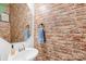 Powder room boasting a brick accent wall, a white basin sink, and unique mirror at 191 Sutters Mill Dr, Troutman, NC 28166