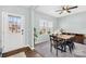 Bright dining room with a modern table set, a ceiling fan, and a large window with natural light at 191 Sutters Mill Dr, Troutman, NC 28166