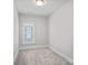 Bright, carpeted bedroom with a window bringing in natural light at 220 Ambleside Village Ln, Davidson, NC 28036