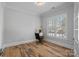 Bright bedroom featuring hardwood floors, a large window, and ample natural light at 220 Ambleside Village Ln, Davidson, NC 28036