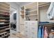 Custom walk-in closet with ample shelving, drawers, and laundry room access at 220 Ambleside Village Ln, Davidson, NC 28036