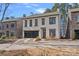 Two story home with stone and stucco exterior, glass garage door, and brick driveway at 220 Ambleside Village Ln, Davidson, NC 28036