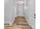 Inviting hallway with hardwood floors, white walls, and elegant lighting at 220 Ambleside Village Ln, Davidson, NC 28036