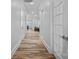 Bright hallway with hardwood floors, white trim, and doors leading to living spaces at 220 Ambleside Village Ln, Davidson, NC 28036