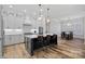 A bright and functional kitchen with a dark island, white cabinets, and pendant lighting at 220 Ambleside Village Ln, Davidson, NC 28036