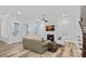 Living room with hardwood floors, fireplace, and a view into the kitchen area at 220 Ambleside Village Ln, Davidson, NC 28036