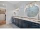 Main bathroom featuring dual sinks, marble countertop, custom cabinets, mirrors, and glass enclosed shower at 220 Ambleside Village Ln, Davidson, NC 28036