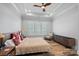 Calm main bedroom with natural light, neutral tones, wood tray ceiling, and hardwood flooring at 220 Ambleside Village Ln, Davidson, NC 28036