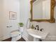 Elegant powder room with pedestal sink, ornate mirror, and modern fixtures at 2240 Mecklenburg Ave, Charlotte, NC 28205