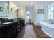 Modern bathroom with double sinks, dark cabinets, a soaking tub and a walk-in shower at 2270 New Gray Rock Rd, Fort Mill, SC 29708