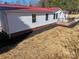 Side view of a ranch home with red metal roof and brick foundation at 291 Patterson Farm Rd, Mooresville, NC 28115