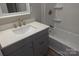 Bathroom with gray vanity, white countertop, and shower/tub combo at 303 Patterson Farm Rd, Mooresville, NC 28115