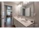 Bright bathroom featuring double sinks and doorway leading to the game room at 3575 Cerelia Ln, Denver, NC 28037