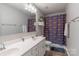 Well-lit bathroom with a double sink vanity, neutral walls, and a themed shower curtain at 3575 Cerelia Ln, Denver, NC 28037