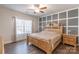 Spacious bedroom with a striking accent wall, ceiling fan, and large window with decorative curtains at 3575 Cerelia Ln, Denver, NC 28037