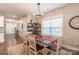 Bright dining room features a modern light fixture, large window, and built-in shelving and bar area at 3575 Cerelia Ln, Denver, NC 28037