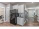 Kitchenette leading into entryway has white cabinets, stainless steel appliances, and granite countertops at 3575 Cerelia Ln, Denver, NC 28037