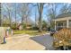 Spacious backyard featuring a concrete patio, lush lawn, mature trees, storage shed, and covered porch at 3939 Sussex Ave, Charlotte, NC 28210