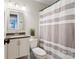 Cozy bathroom with a neutral-toned shower curtain and a granite-topped vanity at 3939 Sussex Ave, Charlotte, NC 28210