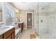 A spa-like bathroom features a double vanity, a stand-alone shower with glass enclosure, and natural light from the window at 3939 Sussex Ave, Charlotte, NC 28210